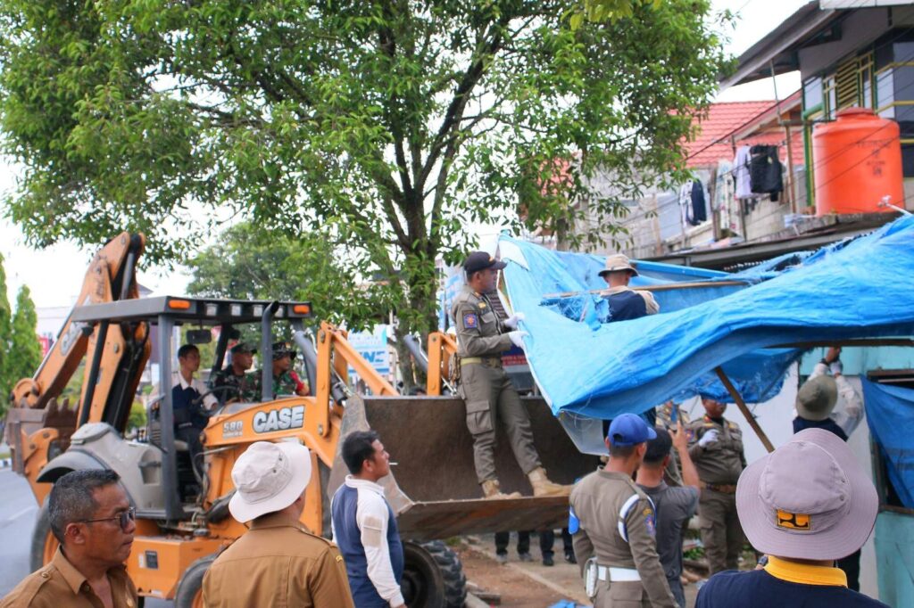 Petugas Satpol PP dan tim terpadu membongkar bangunan liar dengan bantuan alat berat di Payakumbuh.