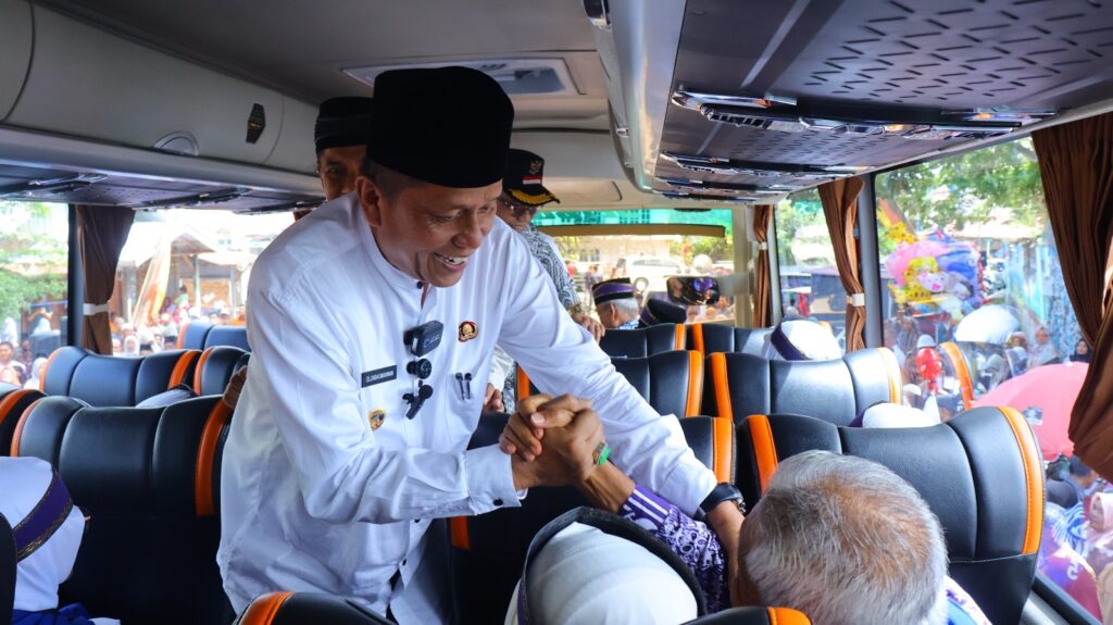 Wakil Wali Kota Payakumbuh Elzadaswarman berjabat tangan dengan jamaah calon haji di dalam bus, saat pelepasan keberangkatan ke Tanah Suci.
