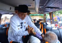 Wakil Wali Kota Payakumbuh Elzadaswarman berjabat tangan dengan jamaah calon haji di dalam bus, saat pelepasan keberangkatan ke Tanah Suci.