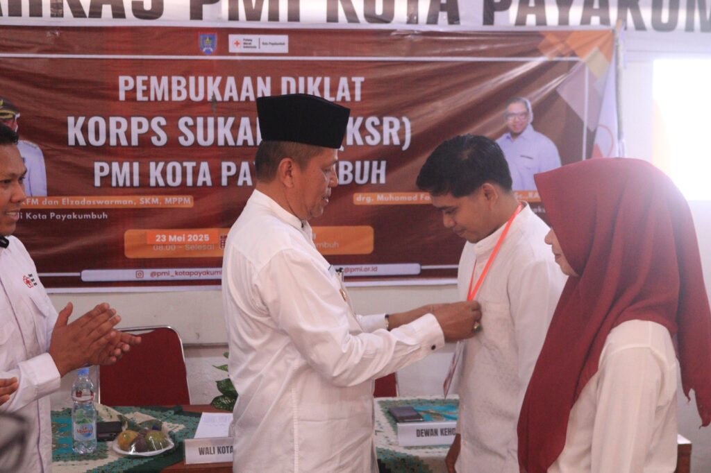 Wakil Wali Kota Payakumbuh, Elzadaswarman, memasangkan tanda peserta kepada relawan dalam pembukaan Diklat KSR PMI Kota Payakumbuh, 23 Mei 2025.