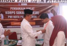 Wakil Wali Kota Payakumbuh, Elzadaswarman, memasangkan tanda peserta kepada relawan dalam pembukaan Diklat KSR PMI Kota Payakumbuh, 23 Mei 2025.