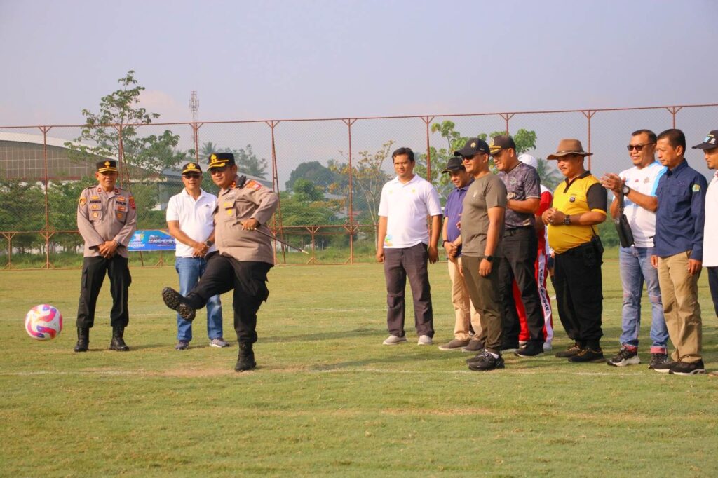 Kapolres Payakumbuh menendang bola dalam pembukaan turnamen sepak bola U-40 antarinstansi di Lapangan Kapten Tantawi.