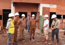 Wali Kota Payakumbuh Zulmaeta bersama tim dinas meninjau proyek pembangunan dengan mengenakan helm pengaman di lokasi konstruksi.