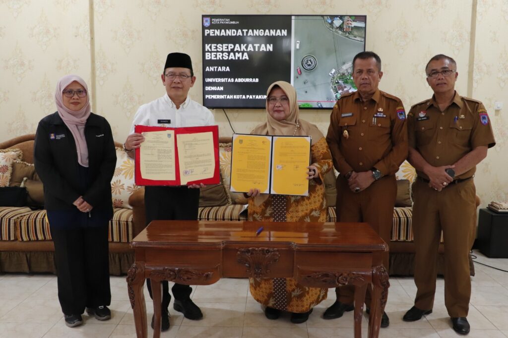 Wali Kota Payakumbuh dan Rektor Universitas Abdurrab menunjukkan dokumen kerja sama usai penandatanganan nota kesepahaman di Pendopo Rumah Dinas Wali Kota.