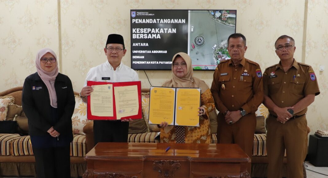 Wali Kota Payakumbuh dan Rektor Universitas Abdurrab menunjukkan dokumen kerja sama usai penandatanganan nota kesepahaman di Pendopo Rumah Dinas Wali Kota.