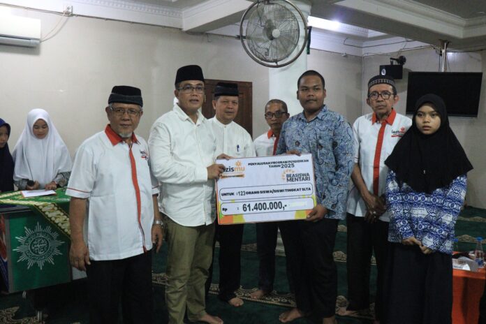 Sekda Payakumbuh Rida Ananda menyerahkan simbolis bantuan Beasiswa Mentari dari Lazismu kepada siswa SLTA, disaksikan pengurus dan penerima beasiswa.