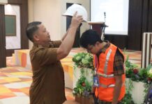 Simbolis penyematan helm keselamatan oleh perwakilan Pemko Payakumbuh dalam kegiatan uji sertifikasi tenaga kerja konstruksi