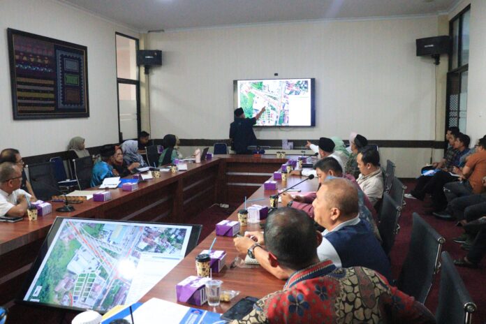 Peserta rapat koordinasi Pemerintah Kota Payakumbuh membahas pemindahan Tugu Kota Sehat dengan menampilkan peta lokasi di layar.