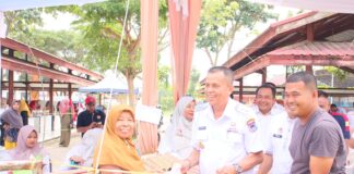 Wakil Wali Kota Payakumbuh Elzadaswarman menyerahkan paket sembako kepada warga pada acara Pasar Murah di Pasar Rakyat Padang Kaduduak.