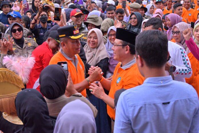 Wali Kota dan Wakil Wali Kota Payakumbuh berjabat tangan dengan penuh semangat di tengah kerumunan warga saat Pawai Alegoris HUT RI ke-80.