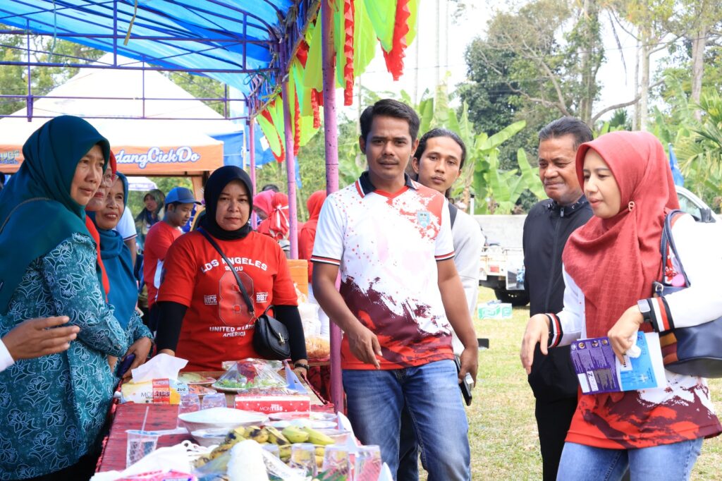 Sejumlah warga dan panitia berbincang di stan bazar UMKM saat perayaan HUT RI ke-80 di Kecamatan Latina, Payakumbuh.