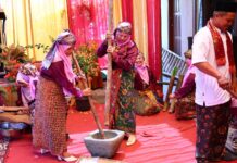 Perempuan Minangkabau mengenakan pakaian adat melakukan prosesi menumbuk padi dalam acara Satu Nagori Satu Iven di Payakumbuh.