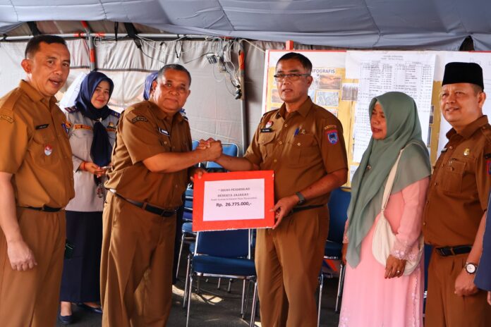 Penyerahan donasi Rp26,7 juta dari Dinas Pendidikan Payakumbuh untuk korban kebakaran Pasar.