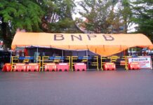 Tenda posko BNPB berwarna oranye dengan pagar pengaman dan spanduk bertuliskan "Posko Bersama Penanggulangan Bencana" di Kota Payakumbuh.