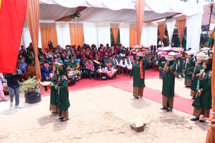 Perempuan Nagari Tiakar mengenakan pakaian adat Minangkabau membawa dulang berisi hidangan dalam tradisi Maanta Pabukoan pada program Satu Nagari Satu Event di Kota Payakumbuh.
