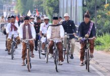 Pejabat dan komunitas ontel bersepeda bersama mengenakan busana tempo dulu dalam Parade Onthel Payakumbuh 2025.