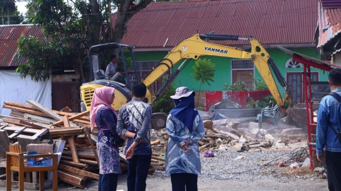 Petugas Dinas PUPR Kota Payakumbuh bersama Satgas Penertiban memantau proses pembongkaran bangunan liar di atas lahan milik pemerintah di Jalan Imam Bonjol, Kamis (13/11/2025).
