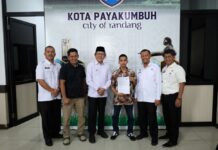 Wali Kota Payakumbuh Zulmaeta berfoto bersama Aditia Alfiki dan jajaran Pemko Payakumbuh usai penyerahan piagam apresiasi atas prestasinya di bidang keamanan siber.