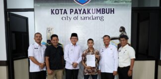 Wali Kota Payakumbuh Zulmaeta berfoto bersama Aditia Alfiki dan jajaran Pemko Payakumbuh usai penyerahan piagam apresiasi atas prestasinya di bidang keamanan siber.