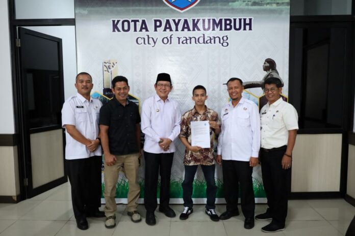 Wali Kota Payakumbuh Zulmaeta berfoto bersama Aditia Alfiki dan jajaran Pemko Payakumbuh usai penyerahan piagam apresiasi atas prestasinya di bidang keamanan siber.