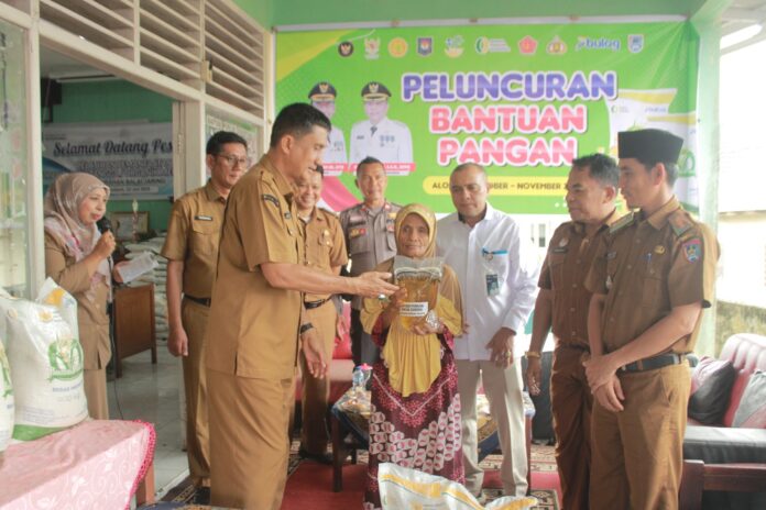 Asisten II Setda Payakumbuh Yasrizal menyerahkan bantuan pangan beras dan minyak goreng kepada seorang warga penerima manfaat pada peluncuran bantuan pangan CPP di Kelurahan Balai Jaring.