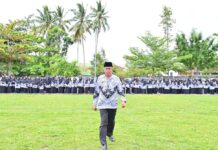 Wakil Wali Kota Payakumbuh berjalan di depan barisan ratusan guru berseragam PGRI saat upacara Hari Guru Nasional di halaman Balai Kota Payakumbuh.