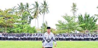 Wakil Wali Kota Payakumbuh berjalan di depan barisan ratusan guru berseragam PGRI saat upacara Hari Guru Nasional di halaman Balai Kota Payakumbuh.