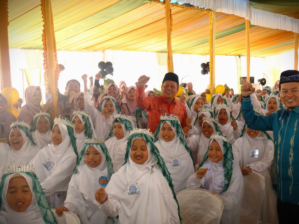 Sejumlah siswa perempuan tampak antusias berfoto bersama Wakil Wali Kota Payakumbuh (mengenakan batik merah) dan mengikuti rangkaian kegiatan wisuda Khatam Al-Qur’an di SD IT Mutiara Hati, Sabtu (22/11/2025).
