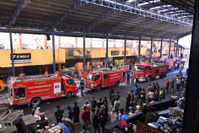 Petugas pemadam kebakaran berjibaku memadamkan api di Pasar Pusat Pertokoan Blok Barat Payakumbuh pascakebakaran.